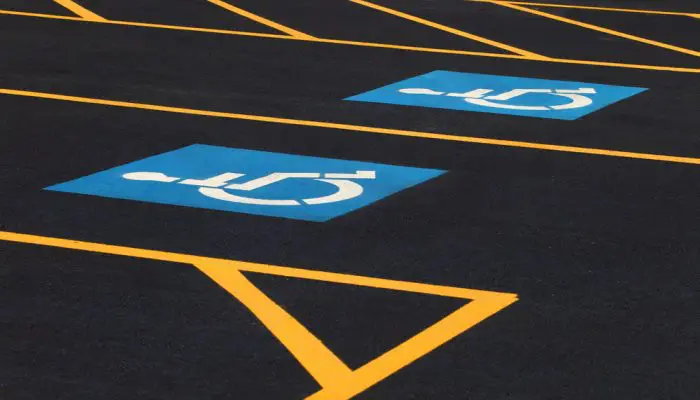 Disabled parking sign on dark asphalt